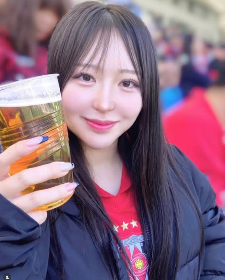 Fan nữ Urawa đây rồi! Gương mặt đỏ bừng mỉm cười dưới ánh hoàng hôn, mái tóc đen lay động trong gió, vòng eo thon thả.